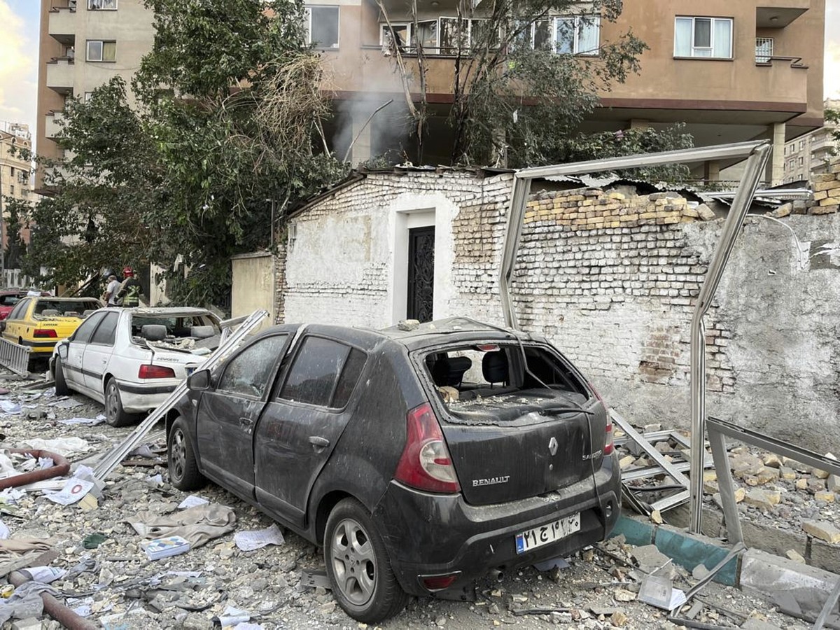 Destroços de um prédio sobre carros em Teerã, no Irã, após ataque de Israel (Foto: Vahid Salemi/AP)