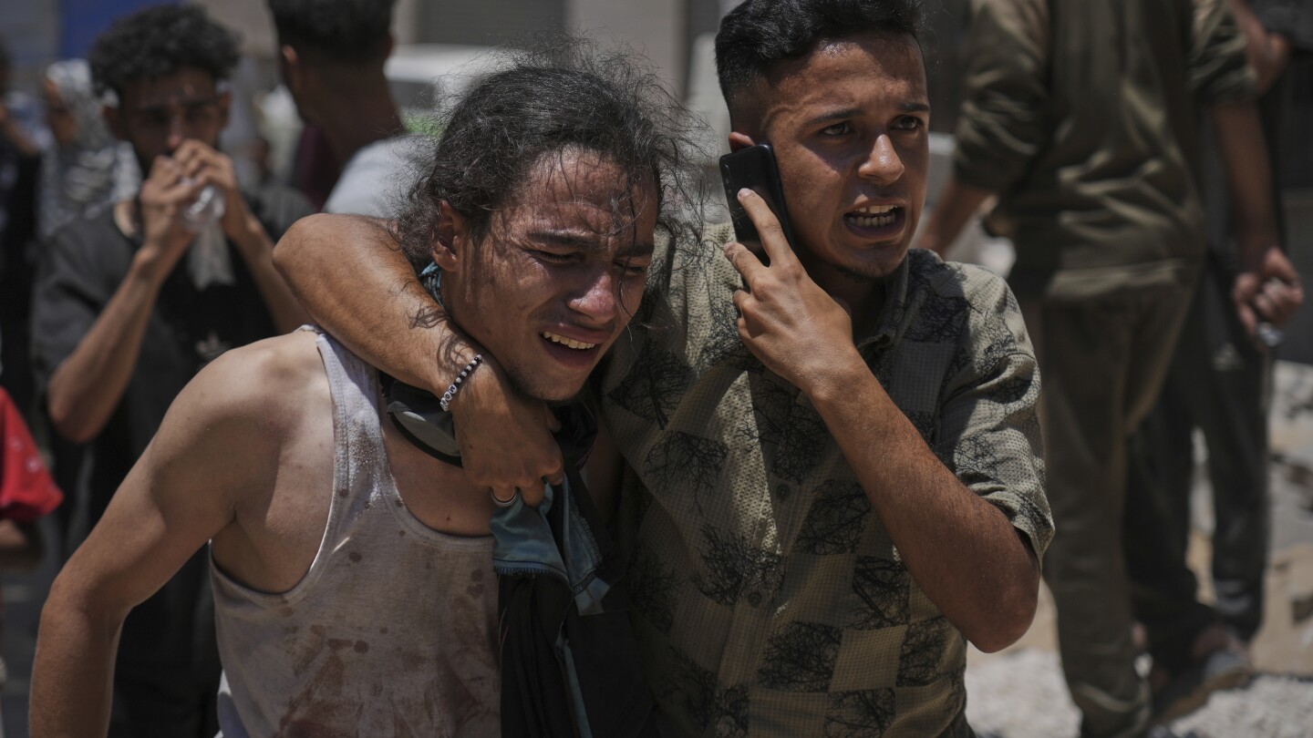 Palestinos reagem após carregar os corpos daqueles que foram mortos enquanto tentavam alcançar os caminhões de ajuda que entravam no norte de Gaza através da passagem de Zikim com Israel, no Hospital Shifa, na Cidade de Gaza, domingo, 20 de julho de 2025. (Foto: AP Photo/Jehad Alshrafi)