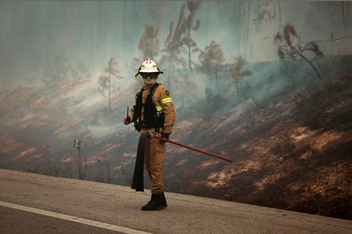 Incêndios forçam evacuação de aldeias e fechamento de estradas em Portugal Bombeiro monitora um incêndio florestal em Pombal, Portugal (Foto: Carlos Costa/AFP)
