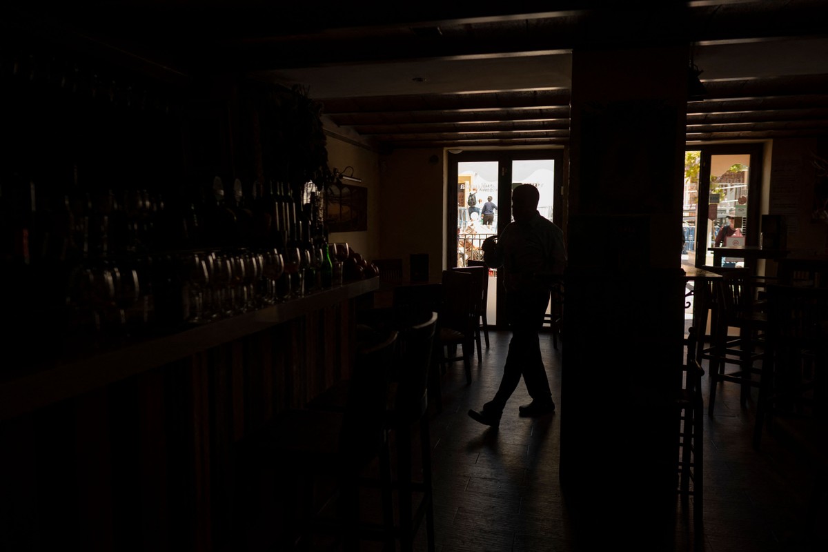 Um barman trabalha no restaurante “La Taberna” sem luz durante um grande apagão que afetou toda a Península Ibérica e o sul da França. (Foto: JORGE GUERRERO/AFP)