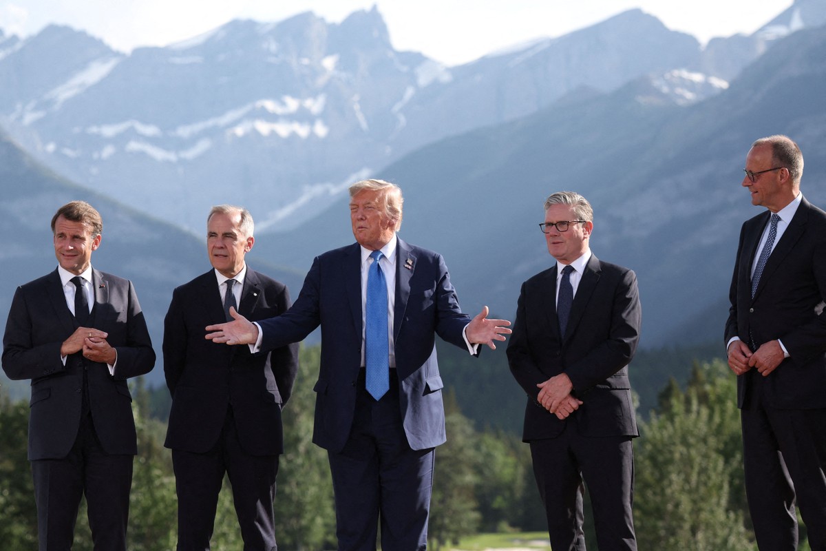 O presidente dos EUA, Donald Trump (ao centro), gesticula ao lado do presidente francês, Emmanuel Macron; do primeiro-ministro canadense, Mark Carney; do premier britânico, Keir Starmer, e do chanceler alemão, Friedrich Merz, durante foto para a Cúpula do Grupo dos Sete (G7) no Canadá (Foto: Suzanne Plunkett / POOL / AFP)