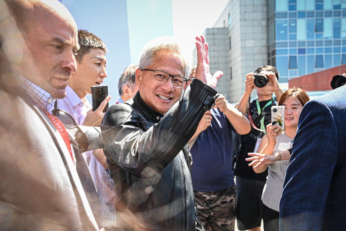 Jensen Huang se torna ícone na China após trajetória de lavador de pratos a CEO Jensen Huang, CEO da Nvidia, acena para a multidão ao sair durante a China International Supply Chain Expo (CISCE), em Pequim, em 17 de julho de 2025 (Foto: Jade GAO / AFP)