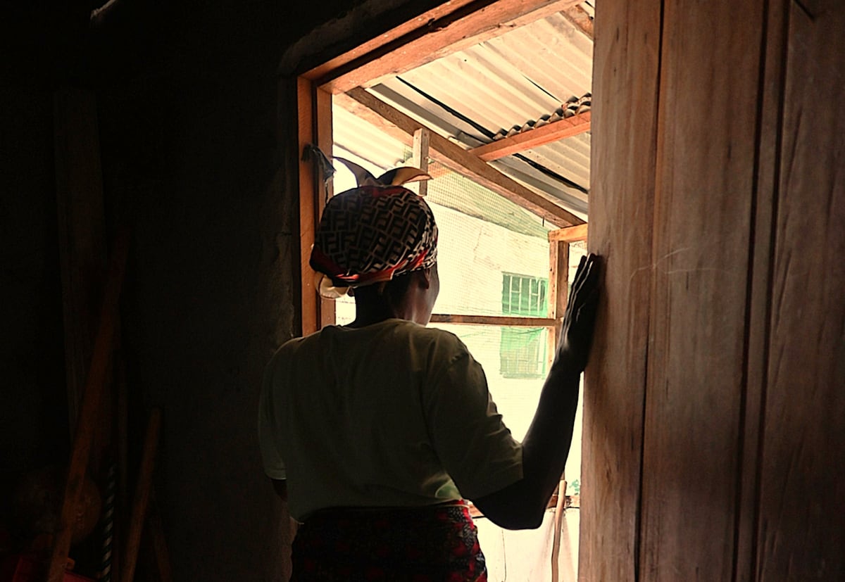 Evelyn (nome fictício) na porta de sua casa, em Monróvia, em maio de 2025 (Foto: Graziana Solano)