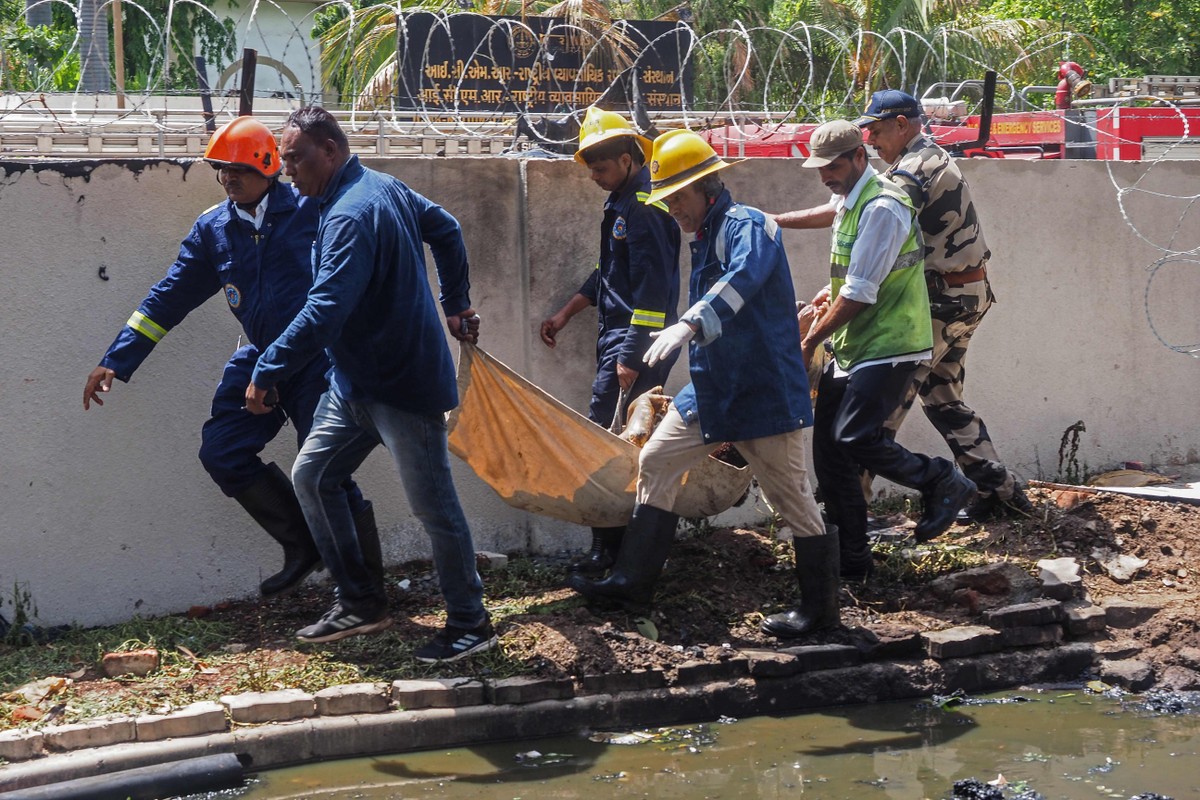 Socorristas retiram vítima do acidente aéreo na Índia (Foto: Sam Panthaky/AFP)