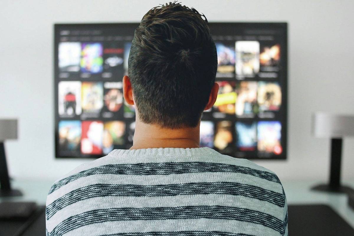 Streaming influencia Congresso e altera relatoria de projeto, gerando preocupações na esquerda Homem assiste a televisão que exibe catálogo de streaming (Foto: Pixabay)
