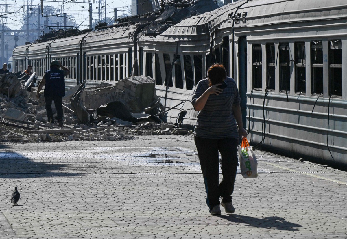 Ataques russos na Ucrânia aumentam enquanto Trump promete fim do conflito Moradora caminha ao lado de trem destruído em Lozova, na região ucraniana de Kharkiv (Foto: Genya SAVILOV / AFP)