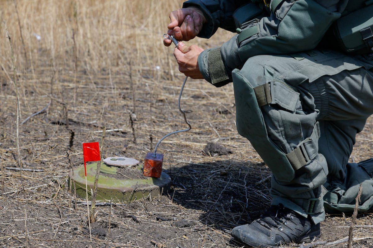 Um zapador russo coloca uma carga explosiva antes de destruir uma mina em uma zona próxima à cidade de Maryinka, na região ucraniana de Donetsk, em 24 de junho. (Foto: Alexander Ermochenko/REUTERS)