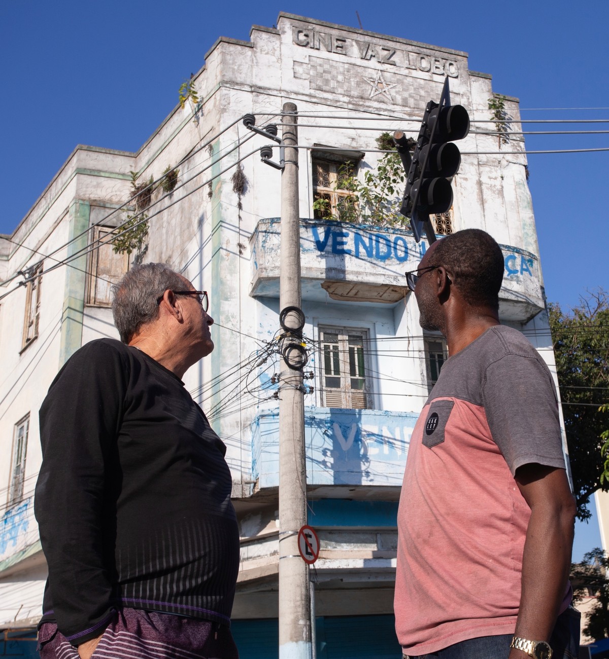 Pereira de Souza (à esquerda) e o vizinho Marcelo Lima relembram os tempos áureos do Cine Vaz Lobo (Foto: Júlia Aguiar)