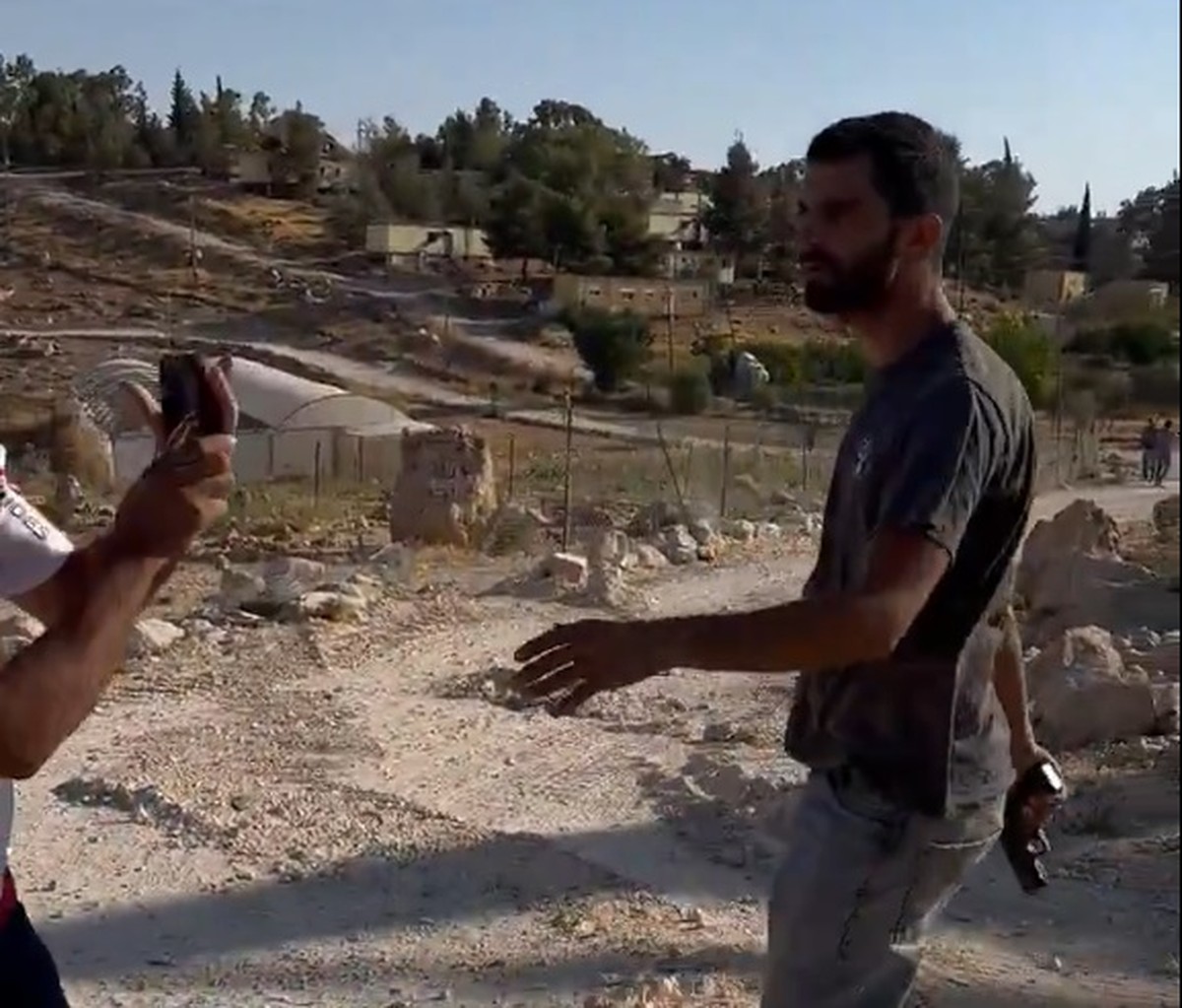 Colono israelense assassina jornalista palestino envolvido em filme premiado Colono israelense Yinon Levi segura pistola pouco antes de disparar contra o ativista e jornalista palestino Awdah Hathaleen (Foto: Reprodução/Redes Sociais)