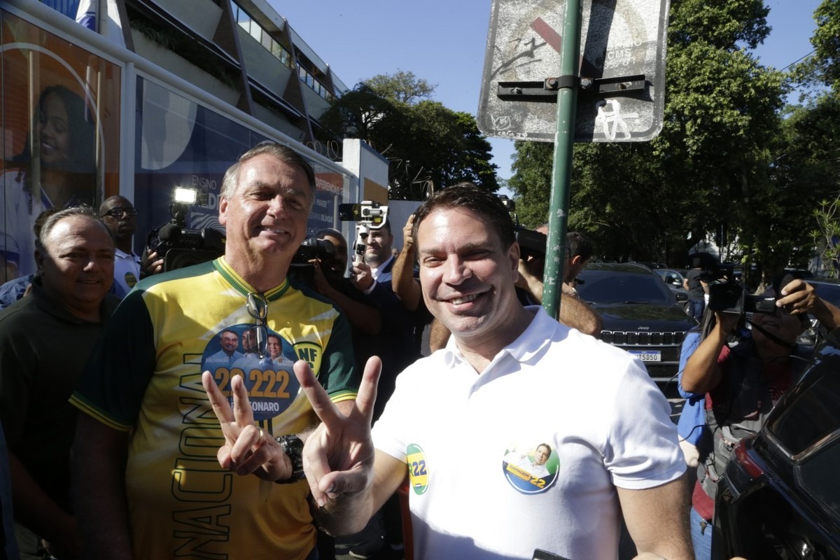 Alexandre Ramagem e o ex-presidente Jair Bolsonaro fazem o 'V' de vitória, após o candidato à Prefeitura do Rio votar na Barra da Tijuca (Foto: Domingos Peixoto/Agência O Globo)