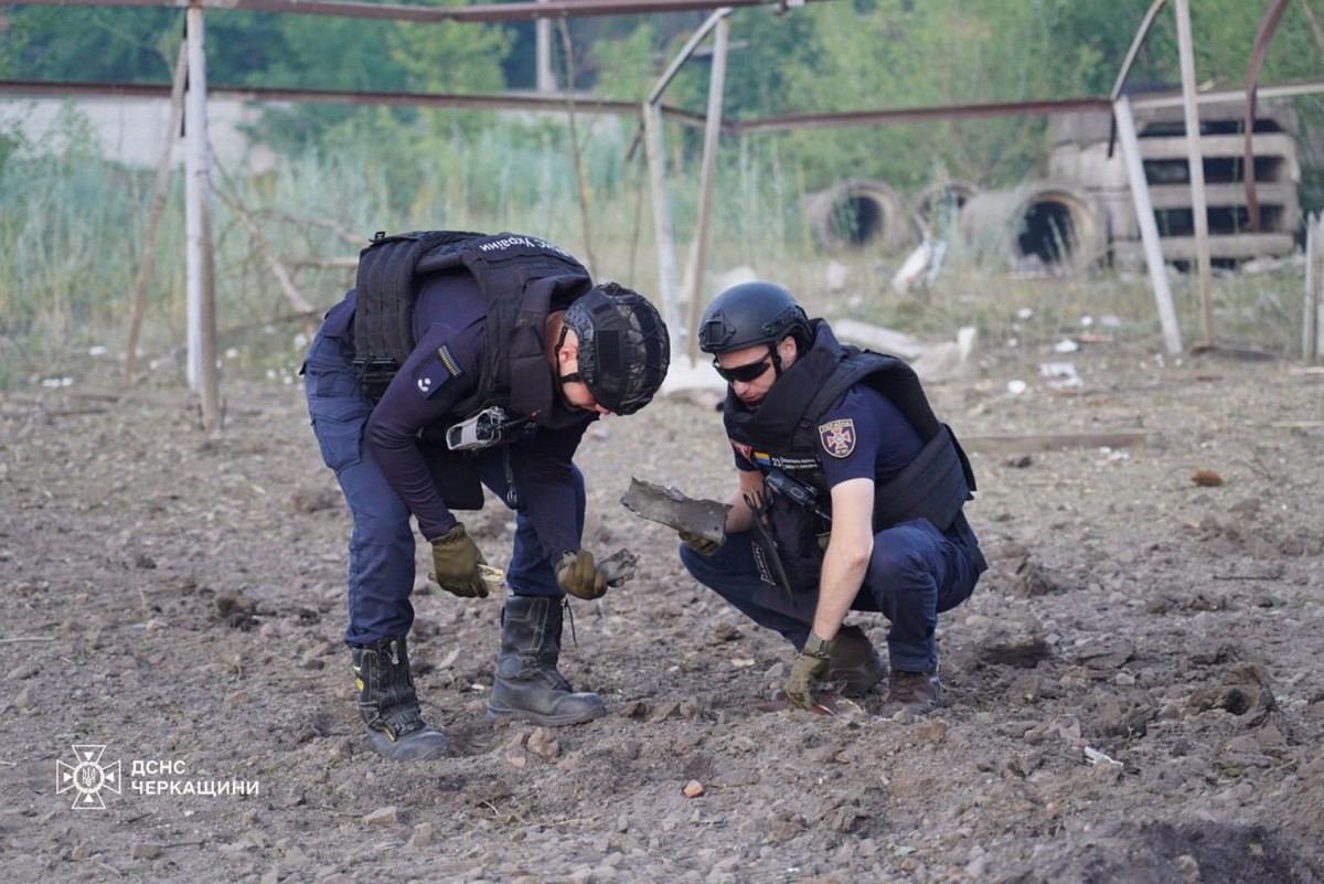 Soldados ucranianos recolhendo fragmentos em um local de ataque russo na cidade de Smila, região de Cherkasy, durante a invasão russa da Ucrânia (Foto: AFP)