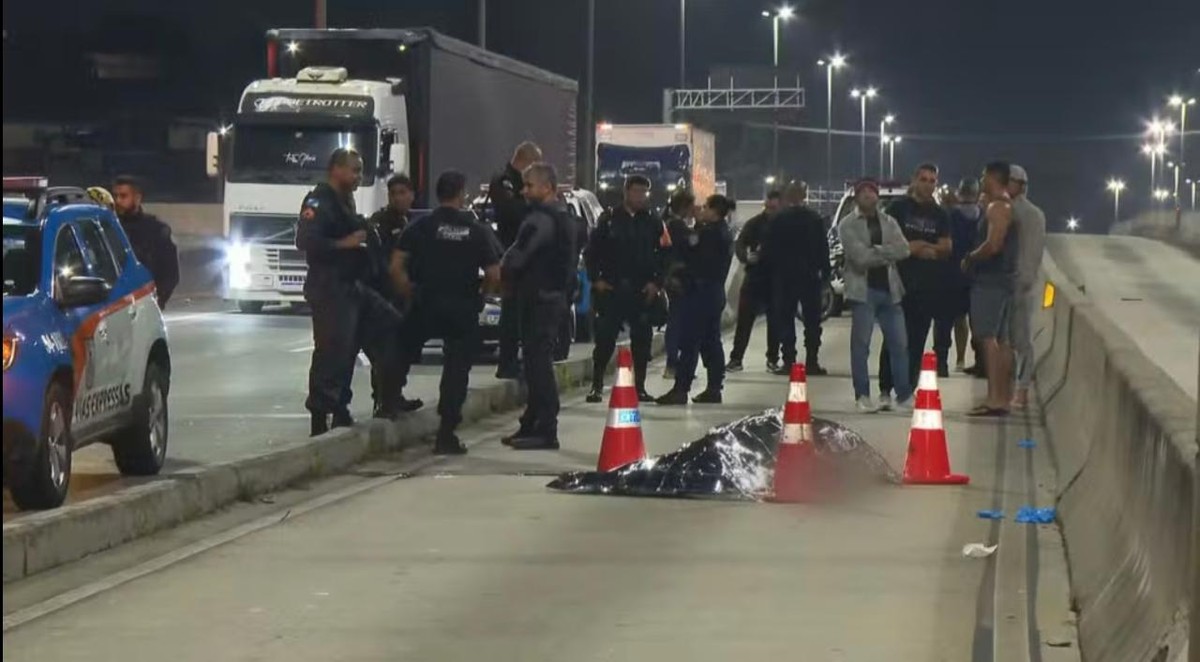 Policiais perto do corpo do agente morto a tiro (Foto: TV Globo/Reprodução)