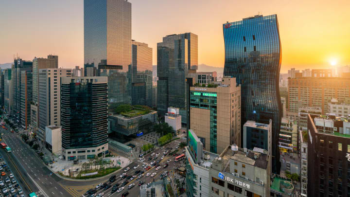 Cenas do pôr do sol com trilhas de luz do tráfego passando por um cruzamento no centro do distrito comercial de Gangnam, na cidade de Seul, Coreia do Sul (Foto: Mongkol Chuewong | Moment | Getty Images)