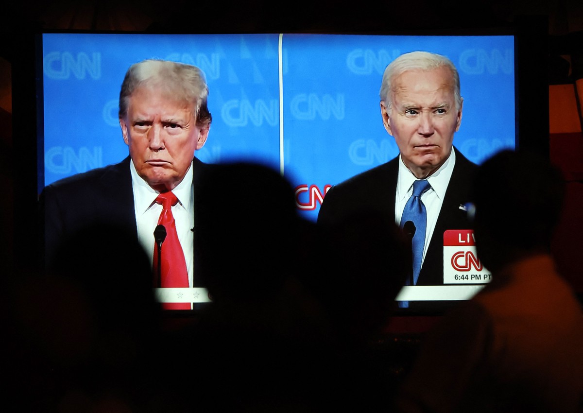 Pessoas assistem ao debate entre o ex-presidente Donald Trump (E) e o presidente dos EUA, Joe Biden (Foto: Mario Tama/Getty Images/AFP)