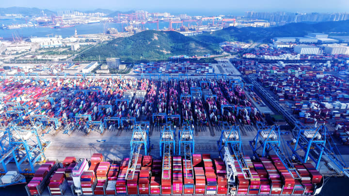 Um navio de carga carrega e descarrega contêineres de comércio exterior no Porto de Qingdao, em Qingdao, na província de Shandong, China, em 25 de julho de 2025. (Foto: Nurphoto | Nurphoto | Getty Images)