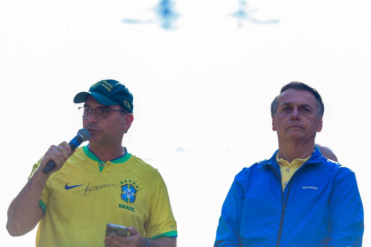 Flávio afirma que escolha do candidato de Bolsonaro será sem vaidade e pede indulto Bolsonaro ao lado do senador Flávio Bolsonaro na manifestação em São Paulo (Foto: Miguel Schincariol/AFP)