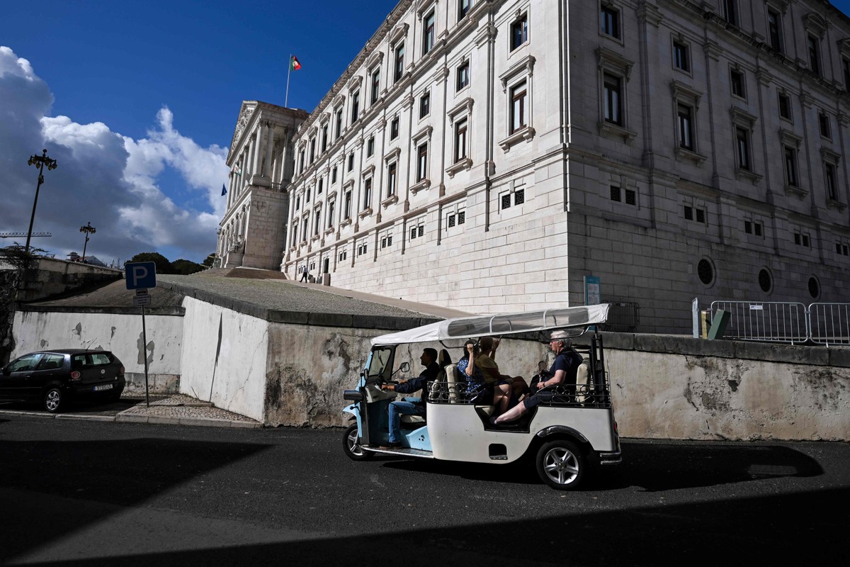Cidadania em Portugal registra aumento antes de mudança na legislação Carrinho de turismo 'tuk tuk' passa em frente ao Parlamento (Foto: Patrícia de Melo Moreira/AFP)