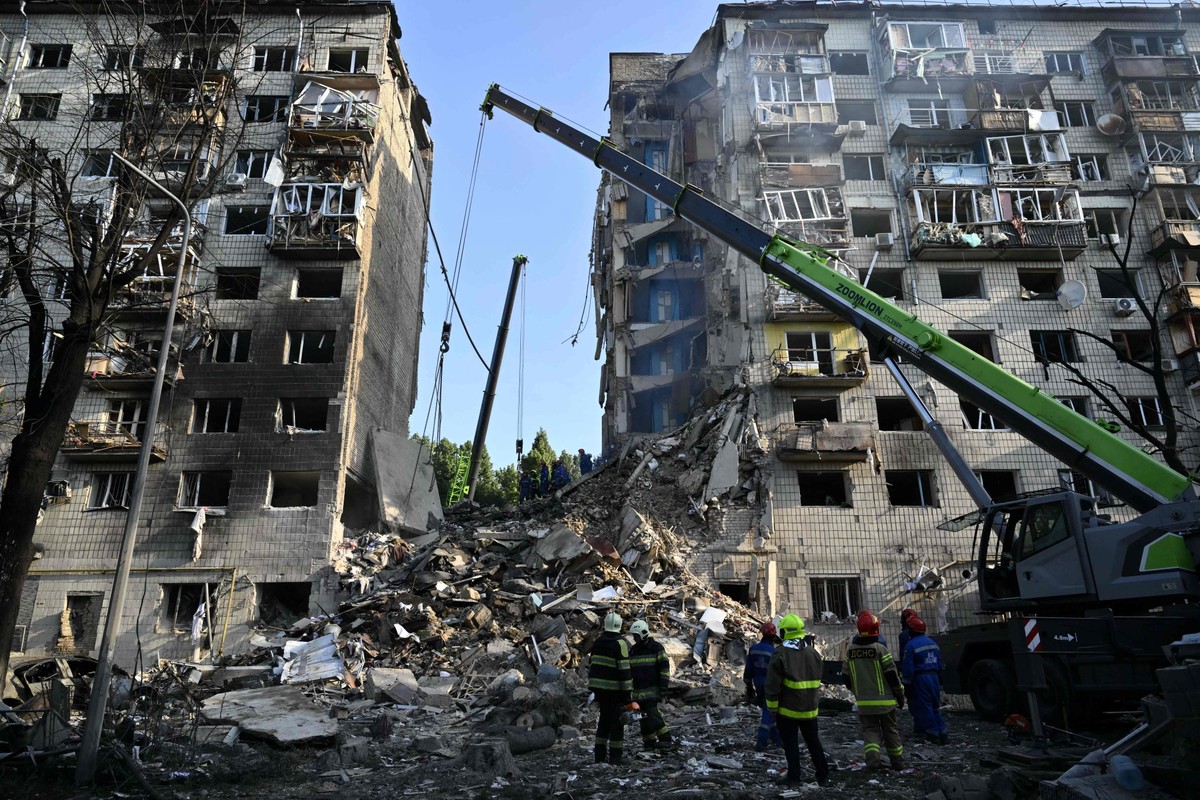 Equipes de resgate ucranianas realizam operações de busca e salvamento em um prédio residencial gravemente danificado após o ataque com mísseis russos em Kiev (Foto: Genya SAVILOV / AFP)