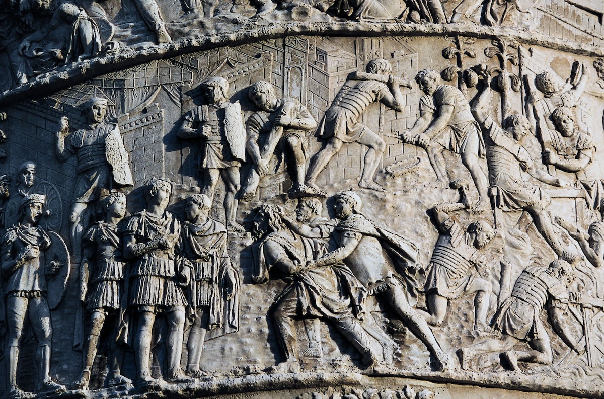 Trajano, imperador romano, enfrenta superpotências como Dácia e Pártia Soldados romanos apresentam prisioneiros dacianos ao imperador Trajano em um relevo na Coluna de Trajano em Roma. (Foto: DEA / W. BUSS (De Agostini via Getty Images))