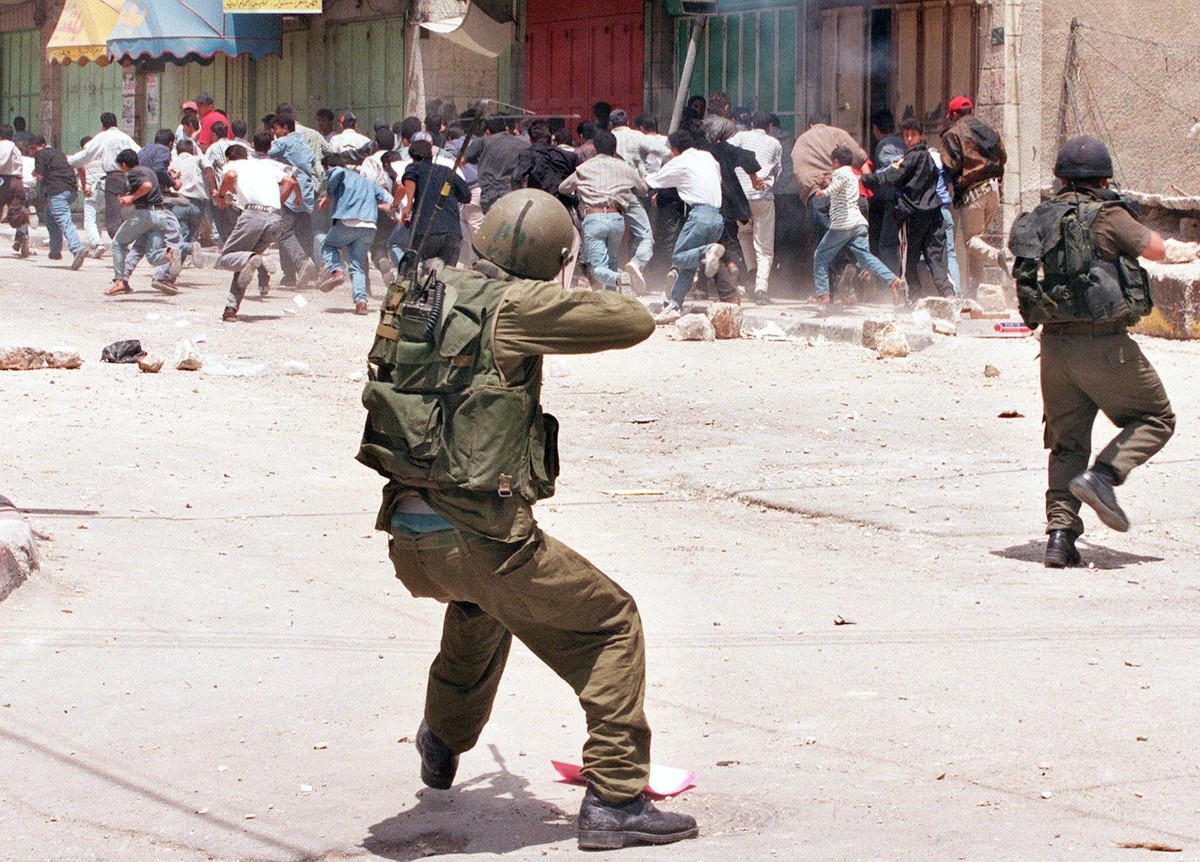 Soldados israelenses disparam balas de borracha contra manifestantes palestinos na Cisjordânia, durante manifestações que marcaram o 50º aniversário de “al-Nakba”, em 1998 (Foto: YOAV LEMMER/AFP)