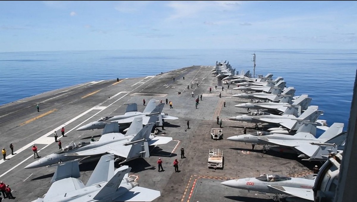 'Relação entre comércio e segurança internacional é analisada por cientista político' Caças são vistos no USS Nimitz durante operações de voo no Mar do Sul da China; porta-aviões deixou o sudeste da Ásia em 16 de junho de 2025 depois de cancelar planos para atracar no Vietnã em meio a informações de que se direciona ao Oriente Médio enquanto os EUA reforçam sua presença na região por causa da guerra entre Israel e Irã (Foto: Edward Jacome / DVIDS / AFP / 28-5-2025)