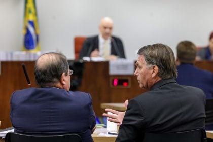 Bolsonaro conversa com o advogado durante o 2º dia de interrogatório da trama golpista no STF. Ao fundo, o ministro Alexandre de Moraes, relator do caso. (Foto: Gustavo Moreno/STF)