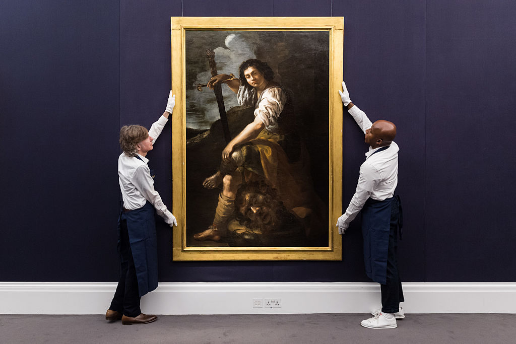 "Antigos mestres ganham destaque em Londres e novidades na Art Basel" Manipuladores de arte seguram uma pintura de Artemisia Gentileschi na Sotheby's antes da venda de Velhos Mestres em Londres em 2025. (Foto: Wiktor Szymanowicz/Future Publishing via Getty Images)